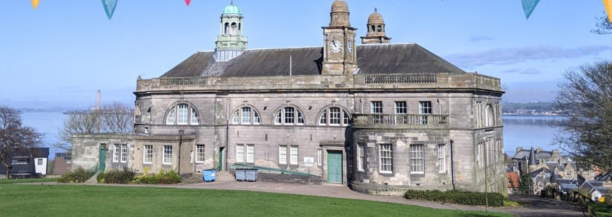 Bo'ness Town Hall on a sunny day with flags graphic.